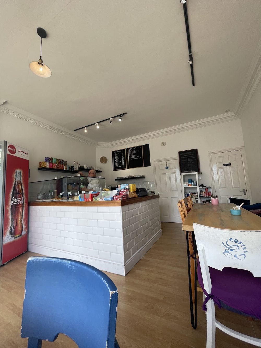 Looking across the seating area, past a blue chair and marble-topped table, towards the counter